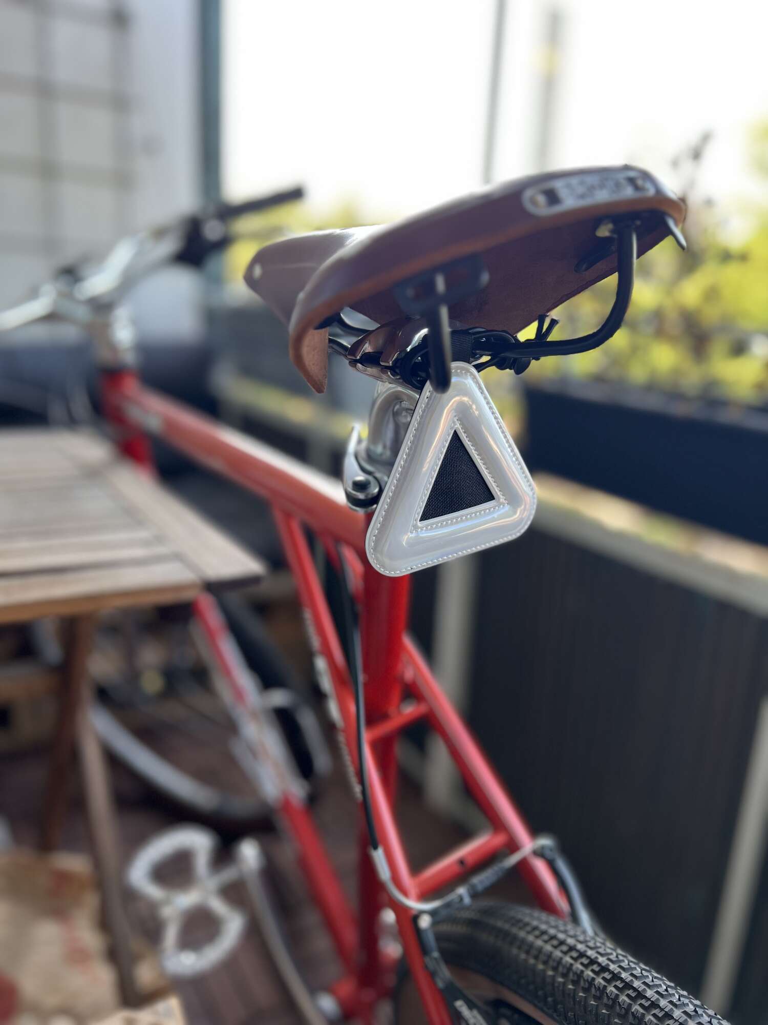 My red bicycle with a leather saddle and a triangular reflector